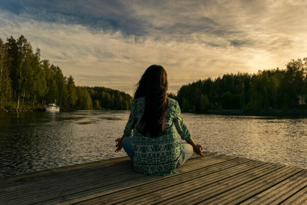 Meditation Frau sitzend am See